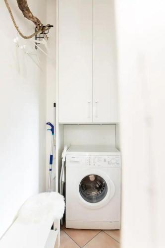 a laundry room with a washing machine and a chair at Il Gelsomino di Ossuccio in Ossuccio