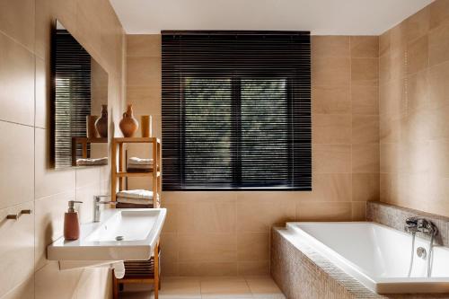 une salle de bain avec une baignoire et un lavabo dans l'établissement Merveilleuses chambres d'hôtes à Panazol, à Panazol