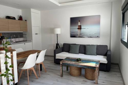 a living room with a couch and a table and a lighthouse at Apartamento de lujo con piscina en Tarifa in Tarifa