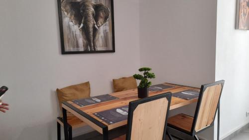 einen Esstisch mit einem Elefantenbild an der Wand in der Unterkunft Nalabba in Dakar