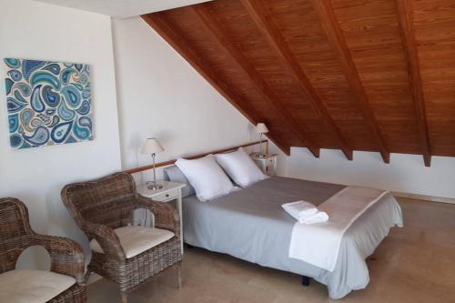 een slaapkamer met een bed en een stoel bij S'Estel. Colònia de Sant Jordi. Mallorca in Colonia Sant Jordi