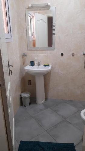 uma casa de banho com um lavatório, um espelho e um WC. em Nalabba em Dakar