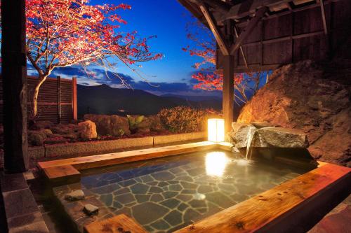 a swimming pool with a table and a tree at Sawaemon in Chino