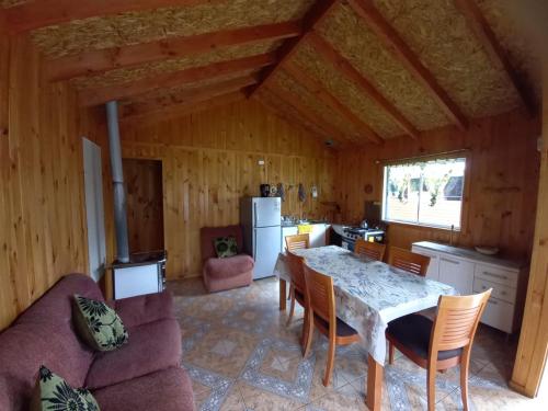 a kitchen and dining room with a table and chairs at Cabañas borde rio in Villarrica