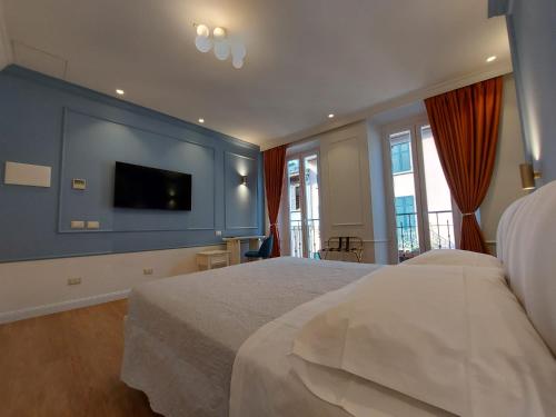 a bedroom with a large bed with a blue wall at Hotel Borgovico in Como