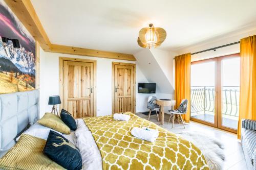 a bedroom with a large bed and a balcony at Dom Wczasowy Tatrzański in Szaflary