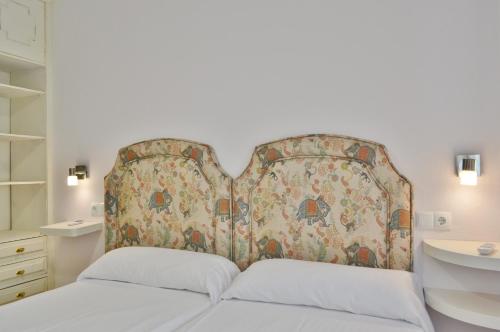 a bedroom with a large headboard and a sink at SunShine Buen Pastor in Córdoba