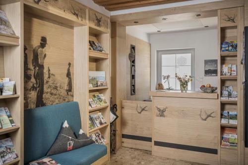 a room with wooden shelves and a blue chair at Café Pension Koller in Brixen im Thale