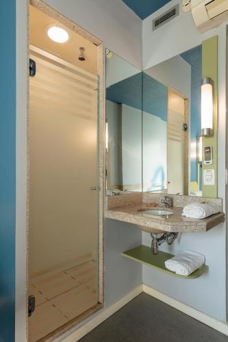 a bathroom with a sink and a mirror at ibis budget BH Afonso Pena Savassi in Belo Horizonte