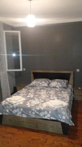 a bedroom with a bed with a blue wall at Pirosmani 66 in Sighnaghi