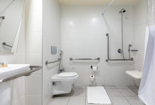 a white bathroom with a toilet and a sink at ibis budget BH Afonso Pena Savassi in Belo Horizonte