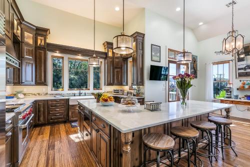 a kitchen with wooden cabinets and a large island with bar stools at de la Bleau B&B in Mandeville