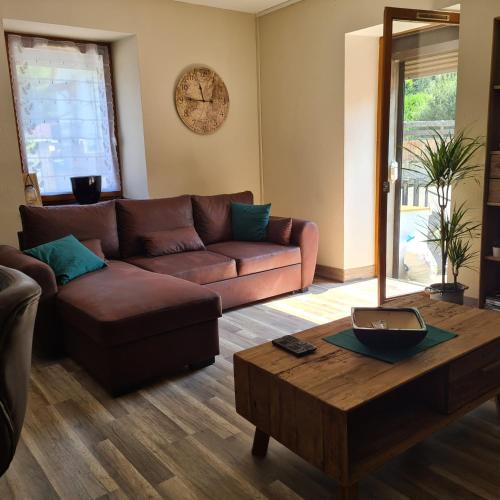 a living room with a couch and a coffee table at Appartement au cœur du Haut-Jura in Villard-Saint-Sauveur