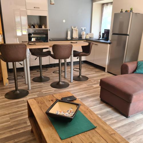 une cuisine et un salon avec une table et des chaises dans l'établissement Appartement au cœur du Haut-Jura, à Villard-Saint-Sauveur