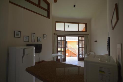 uma cozinha com um balcão, um frigorífico e uma janela em Residencial e Pousada com Piscina Farol 1245,10 em Florianópolis