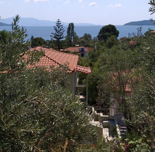 uma casa com telhado vermelho e árvores em Villa Bloom em Achladies