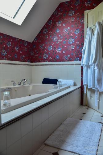 a bathroom with a bath tub and floral wallpaper at The Yellow Rose of Talbot Bed and Breakfast in Easton