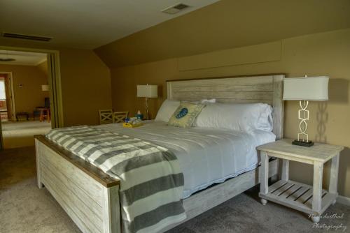 a bedroom with a bed and a table with a lamp at The Yellow Rose of Talbot Bed and Breakfast in Easton