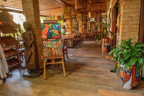 a room with paintings on display in a restaurant at Pousada João Sol in Praia do Forte