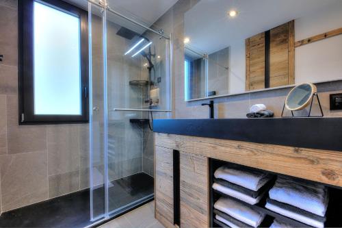 une salle de bain avec une douche en verre et un lavabo dans l'établissement Appartement familial au pied de la télécabine 4*, à Saint-Gervais-les-Bains