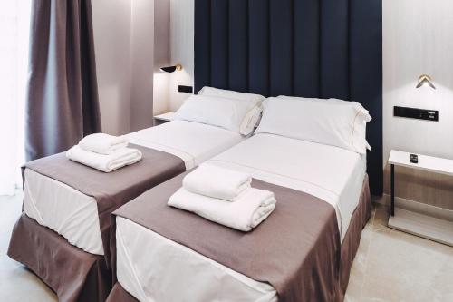 a bedroom with two beds with white towels on them at GBH Hotel-Apartamentos Estrella de Mar in Benidorm