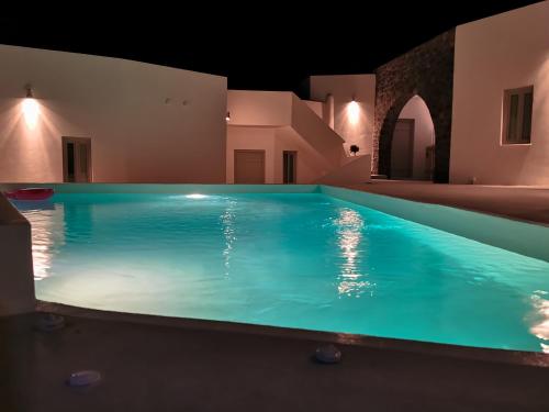 a swimming pool at night in a house at Noir Santorini in Monolithos