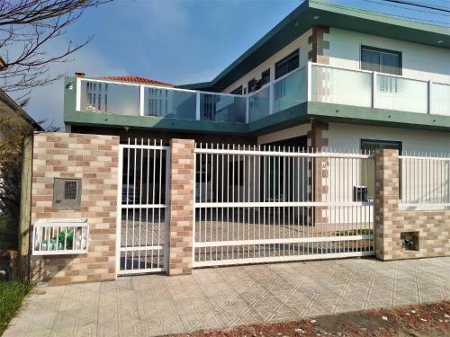 uma casa com um portão branco e vedação em Pousada Souza em Florianópolis