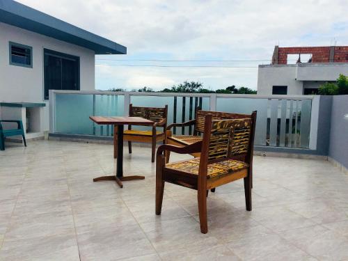 two chairs and a table on a balcony at Pousada Souza in Florianópolis