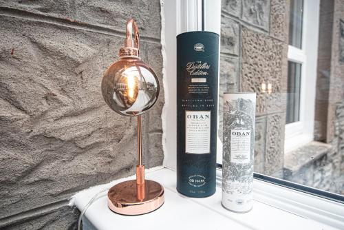 eine Lampe auf einem Tisch neben einer Flasche Wein in der Unterkunft Barriemore Oban in Oban