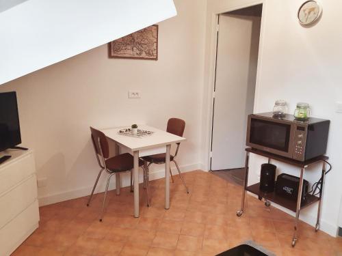 une petite cuisine avec une table et un micro-ondes dans l'établissement Le Kiwitier - corporate apartments closest Innovel&Noveos (studio 19m²), à Clamart