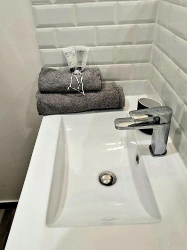 La salle de bains est pourvue d'un lavabo blanc et d'une serviette. dans l'établissement Le Kiwitier - corporate apartments closest Innovel&Noveos (studio 19m²), à Clamart