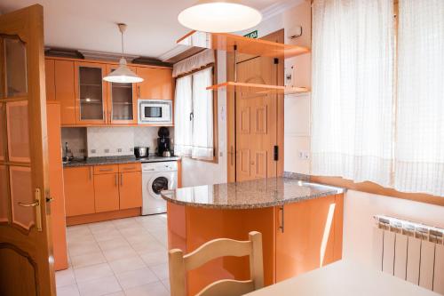 a kitchen with orange cabinets and a counter top at Apartamentos Torre Cristina in Noja