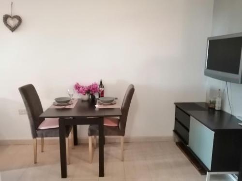 a dining room with a table and chairs and a tv at Sun & Love Apartment in Koper