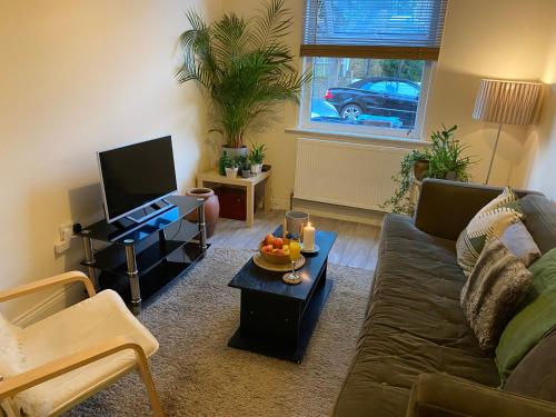 a living room with a couch and a coffee table at 35 mins to central London. 3 bedrooms. 2 bathrooms with garden in London
