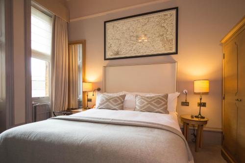 a bedroom with a large white bed with two lamps at The Milner York in York