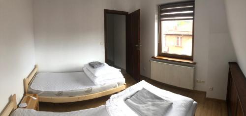 Duas camas num quarto com uma janela em NAD GALERIĄ em Duszniki Zdrój