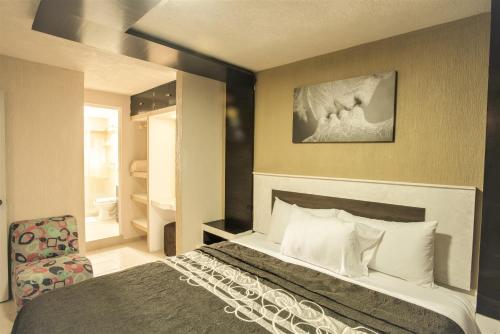 Habitación de hotel con cama y silla en CASA LA VISTA San Miguel De Allende, en San Miguel de Allende