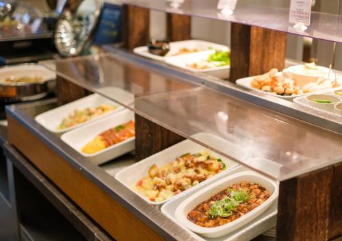 a buffet line with many plates of food on display at APA Hotel Kanazawa Ekimae in Kanazawa