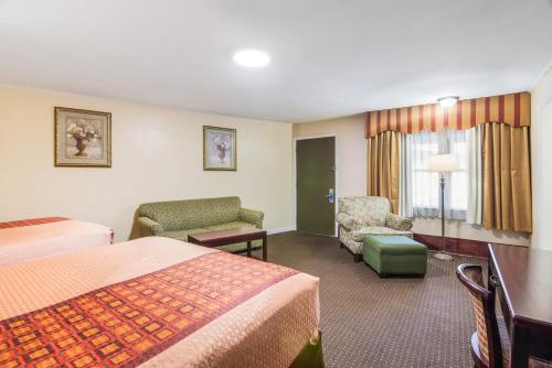 Habitación de hotel con 2 camas y escritorio en Rodeway Inn & Suites Weedsport NY en Weedsport