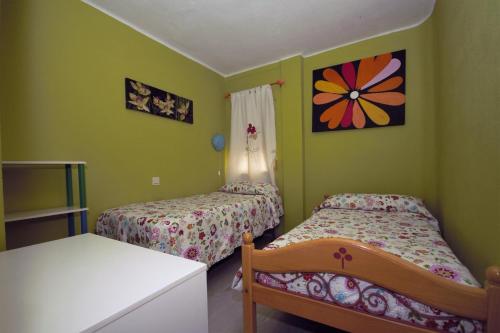 2 Betten in einem Zimmer mit grünen Wänden in der Unterkunft Apartamento La Cordobesita in San Luis de Sabinillas