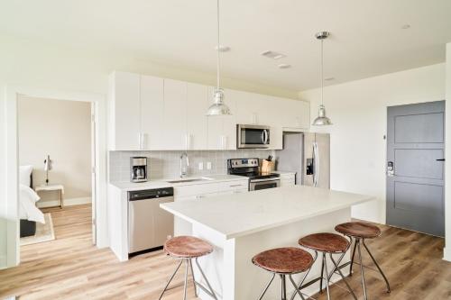 a kitchen with white cabinets and a counter with stools at Sonder at LC SoBro in Nashville