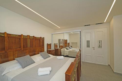 a large bedroom with two beds and a mirror at DIMORE DEL CENTRO - Domus Coeli in Salò