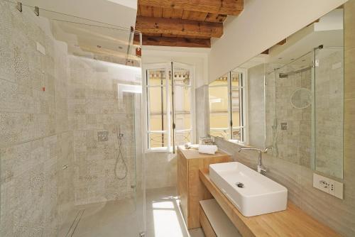 a bathroom with a sink and a shower and a mirror at DIMORE DEL CENTRO - Domus Coeli in Salò