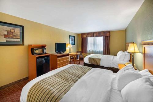 una camera d'albergo con due letti e una televisione di HUTCHI BELL a South Hutchinson