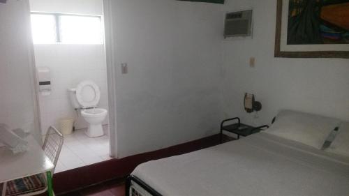 a bathroom with a bed and a toilet in a room at VILLA GLADHYS CASA CAMPESTRE in Honda