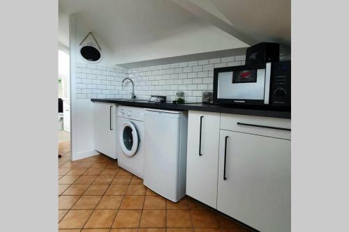une cuisine avec un lave-linge et un micro-ondes dans l'établissement G3 - Le Kiwitier - corporate apartment closest Innovel Noveos Ecole Ducasse Paris Campus - T2 31m2, à Clamart