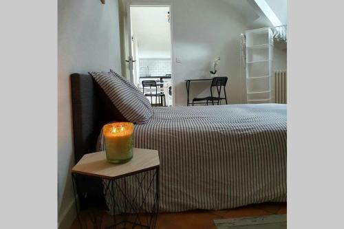 - une chambre dotée d'un lit avec une bougie sur une table dans l'établissement G3 - Le Kiwitier - corporate apartment closest Innovel Noveos Ecole Ducasse Paris Campus - T2 31m2, à Clamart