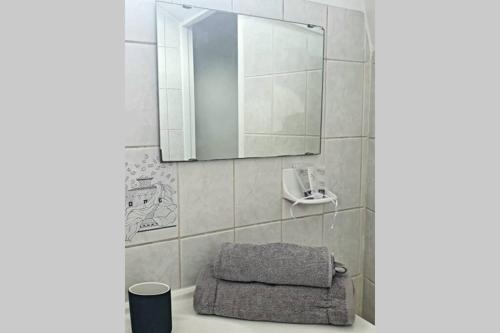 La salle de bains est pourvue d'un lavabo, d'un miroir et d'une serviette. dans l'établissement G3 - Le Kiwitier - corporate apartment closest Innovel Noveos Ecole Ducasse Paris Campus - T2 31m2, à Clamart