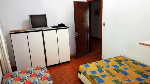 1 dormitorio con 1 cama y TV en un armario en Casa de campo c piscina e churrasq - Mairipora - SP, en Mairiporã