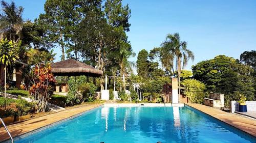 una gran piscina con cenador y árboles en Casa de campo c piscina e churrasq - Mairipora - SP, en Mairiporã